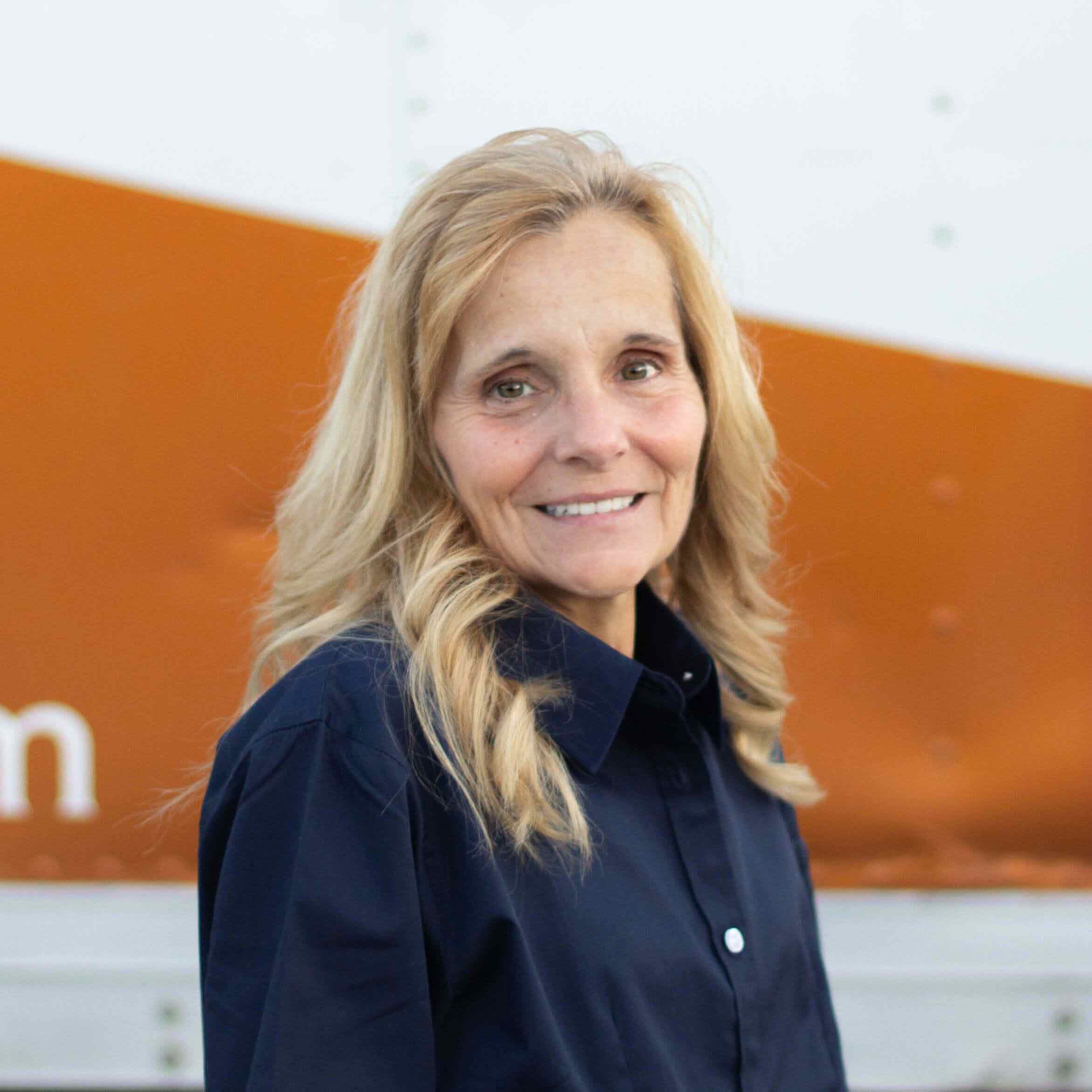 Tammy T., Accounting team member at Lincoln Heating & Air, smiling in front of a service vehicle.