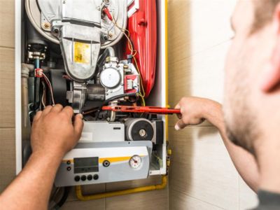 Technician performing maintenance on a boiler system, inspecting components and using tools to ensure efficient operation and prevent breakdowns.