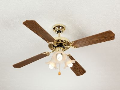 Ceiling fan with wooden blades and light fixture, illustrating energy-efficient airflow management for home comfort and cost savings.